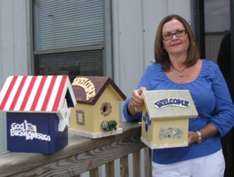 Volunteer paints birdhouses for Habitat Scholarship Fund