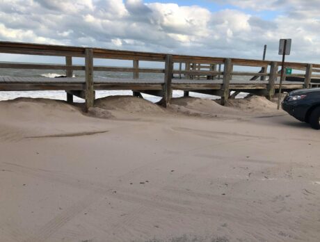 Wind-blown beach sand piles up on parking area at Conn Beach