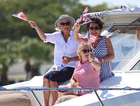 Friendly flotilla shows the flag at Moorings boat parade