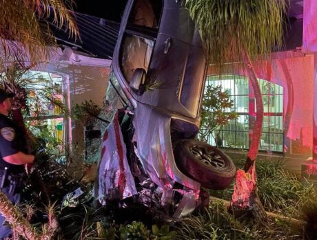 Woman hurt after truck flips onto home